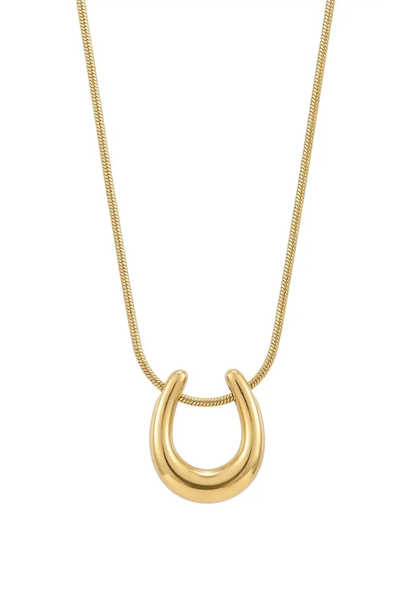 A gold horseshoe pendant necklace on a delicate gold chain, shown against a plain white background.