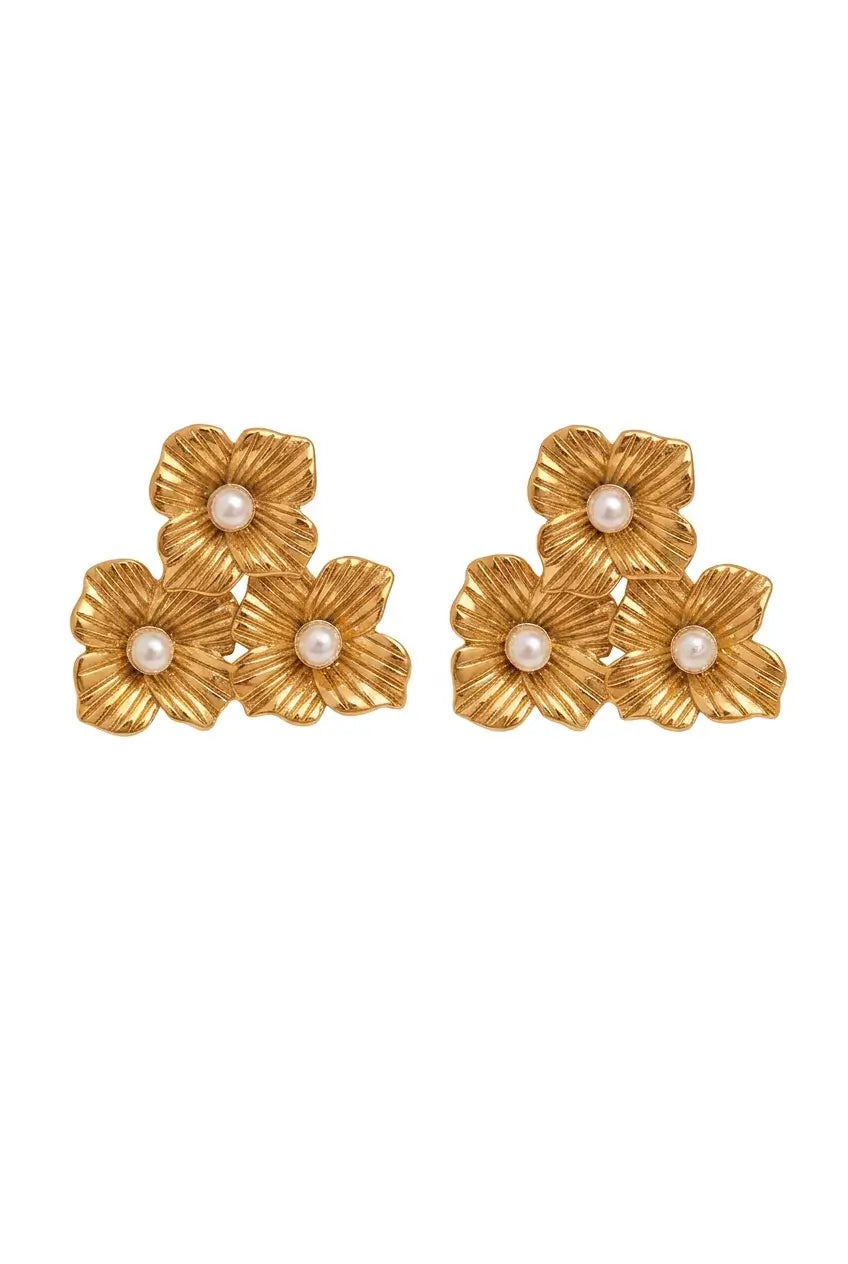 A pair of gold-toned flower-shaped earrings with small white pearl centers, arranged symmetrically on a plain white background.
