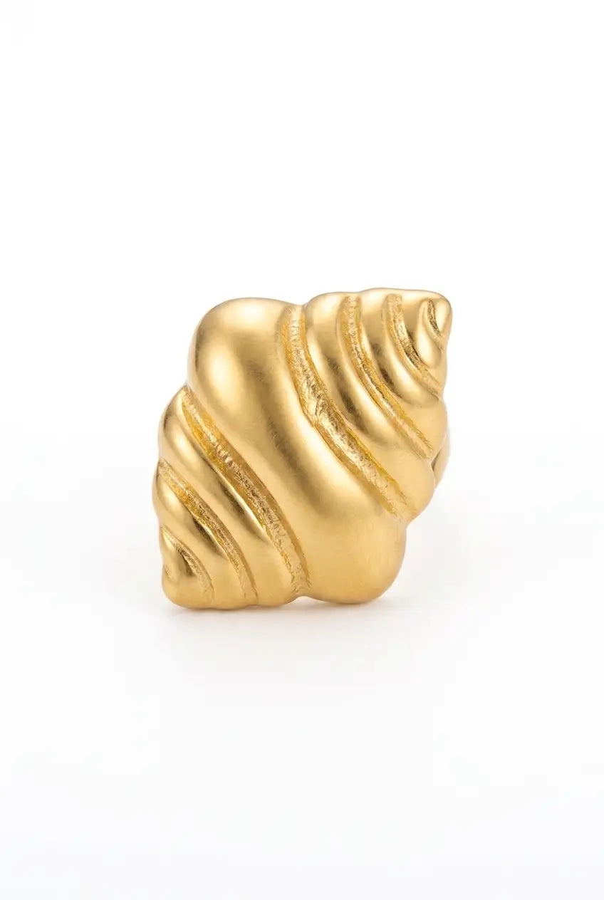 A gold-colored ring designed to look like a spiral seashell, shown on a plain white background.