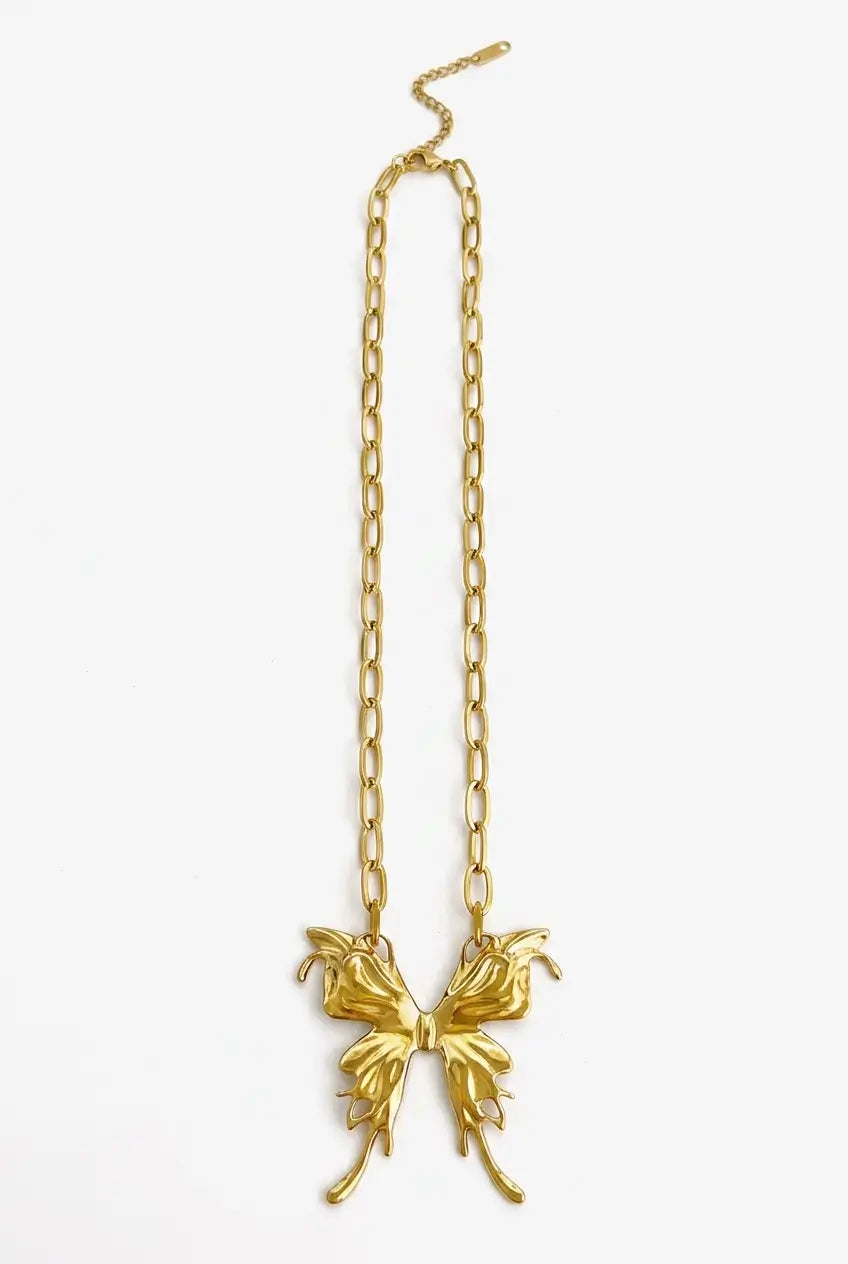 A gold chain necklace featuring a sculptural, textured butterfly pendant, displayed against a clean white background.