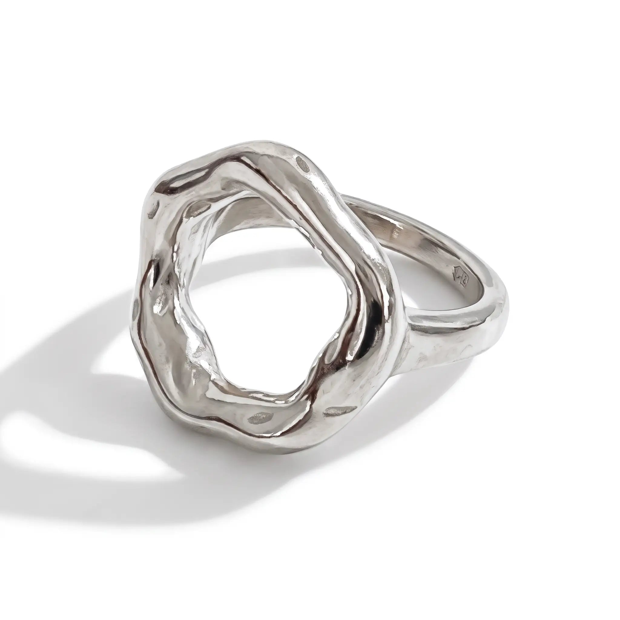A polished silver ring with an organic, wavy, open geometric design, photographed on a clean white background with a soft shadow.
