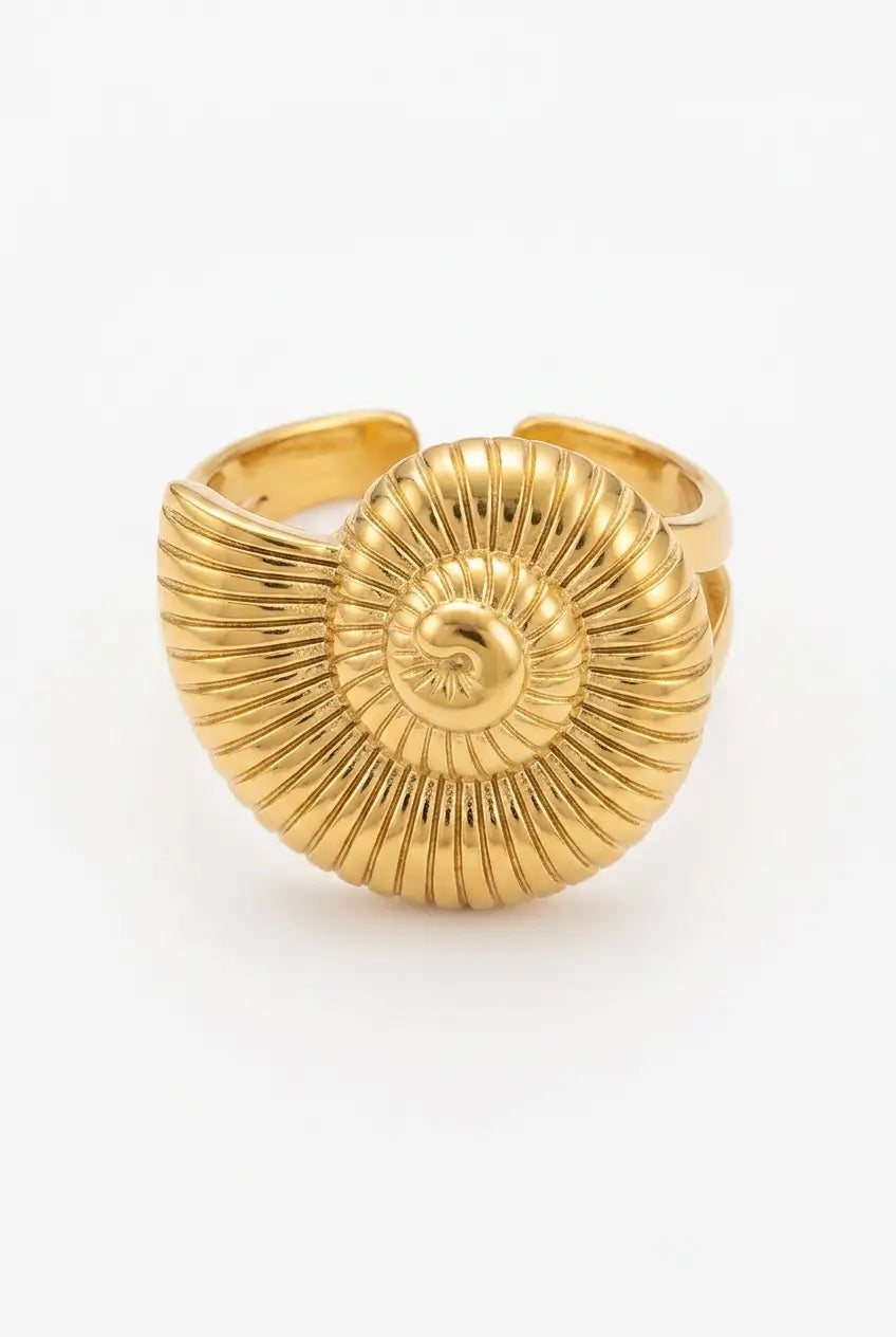 A gold-toned adjustable ring designed to look like a spiral nautilus shell, featuring a ribbed textured shell face and matching band, shown on a plain white background.