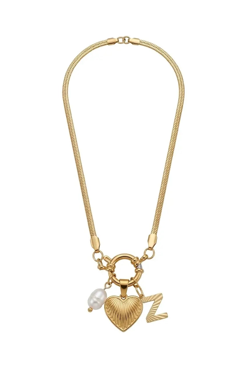 Gold chain necklace with a toggle clasp, featuring a textured heart charm, a small white pearl bead, and a letter 'Z' charm, displayed on a solid white background.