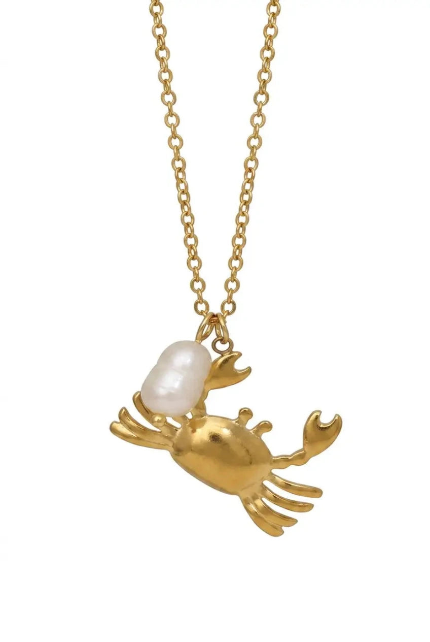 A gold chain necklace featuring a gold crab pendant with a white baroque pearl as its shell, shown against a plain white background.