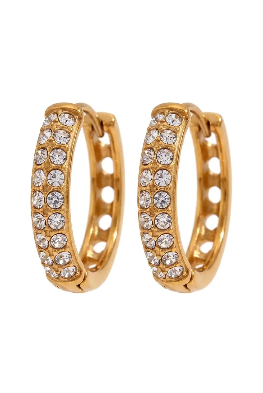 A pair of gold hoop earrings embellished with clear pavé-set round crystals, shown against a plain white background.