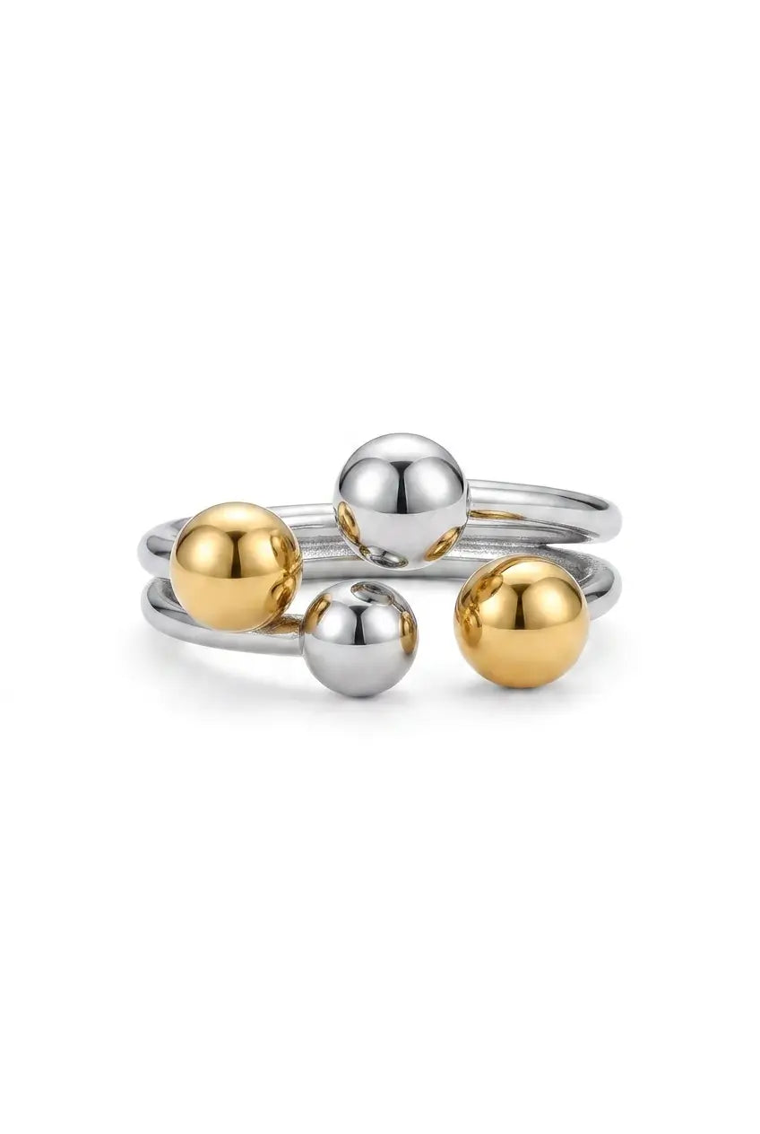 A two-tone silver and gold ball ring with four polished metallic spheres on a thin silver band, photographed on a clean white background.