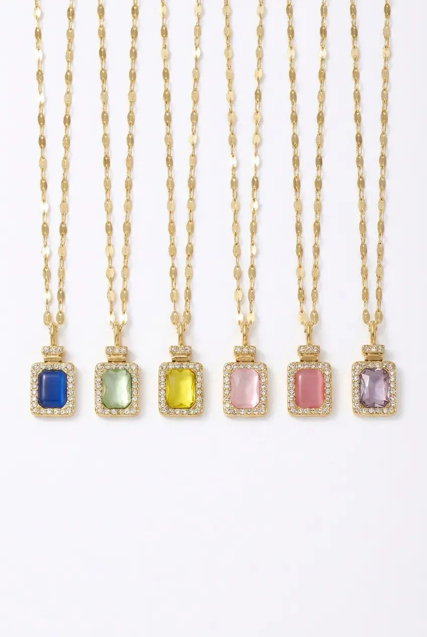 Six gold necklaces with rectangular bezel-set gemstone pendants in different colors (blue, light green, yellow, pink, dusty pink, and lavender) arranged vertically on a white background.