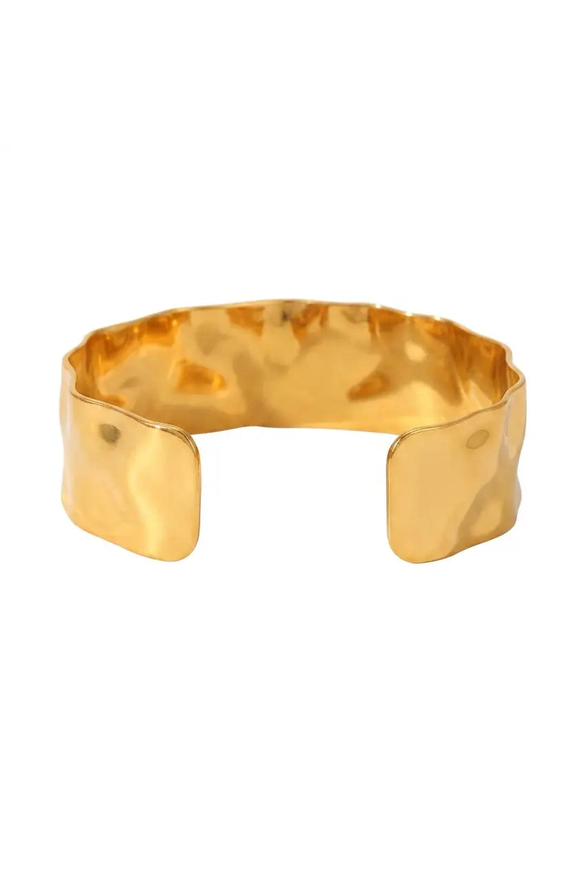 A hammered gold cuff bracelet with a wide, open design, shown on a plain white background.