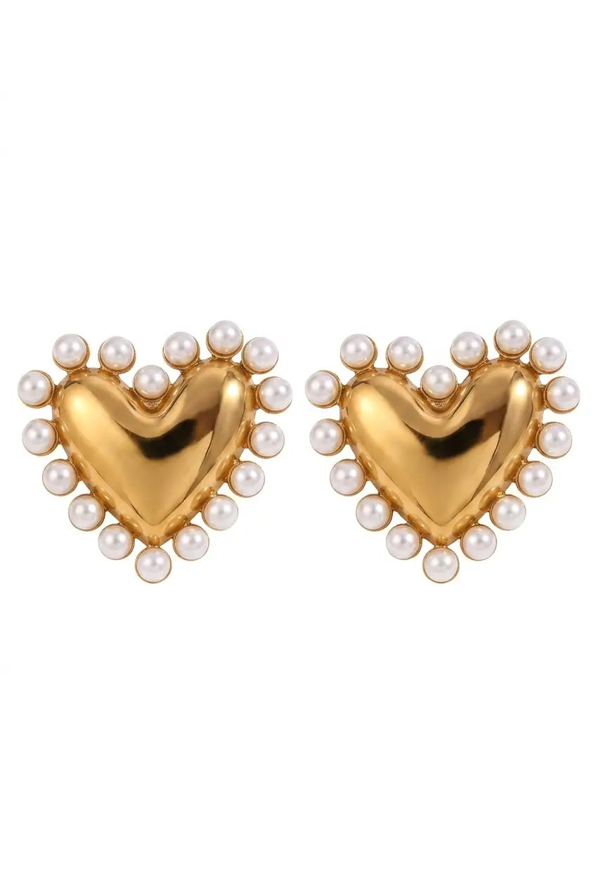 A pair of gold heart-shaped stud earrings, each adorned with a border of small white faux pearls, set against a plain white background.