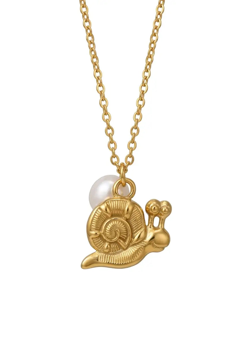 A gold chain necklace featuring a snail-shaped pendant with a textured gold shell and body, accented by a small white pearl bead on the side, shown against a plain white background.