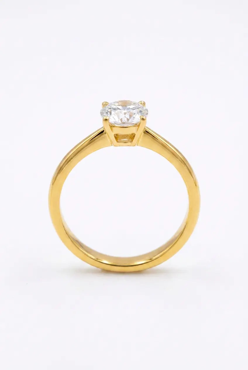A yellow gold solitaire engagement ring with a round brilliant-cut diamond set in a four-prong setting, shown on a clean white background.