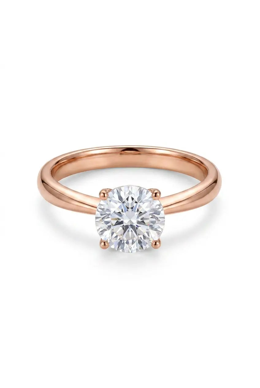A rose gold solitaire engagement ring with a round brilliant-cut diamond set in a four-prong setting, shown on a clean white background.