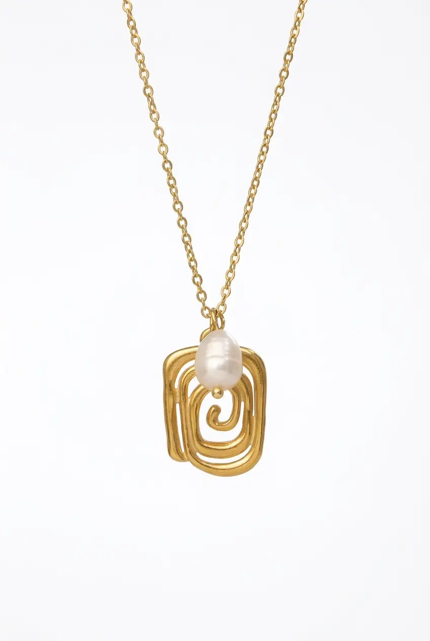 A gold chain necklace featuring a sculptural, openwork spiral pendant in gold, with a small, lustrous white pearl suspended at the center, set against a plain white background.