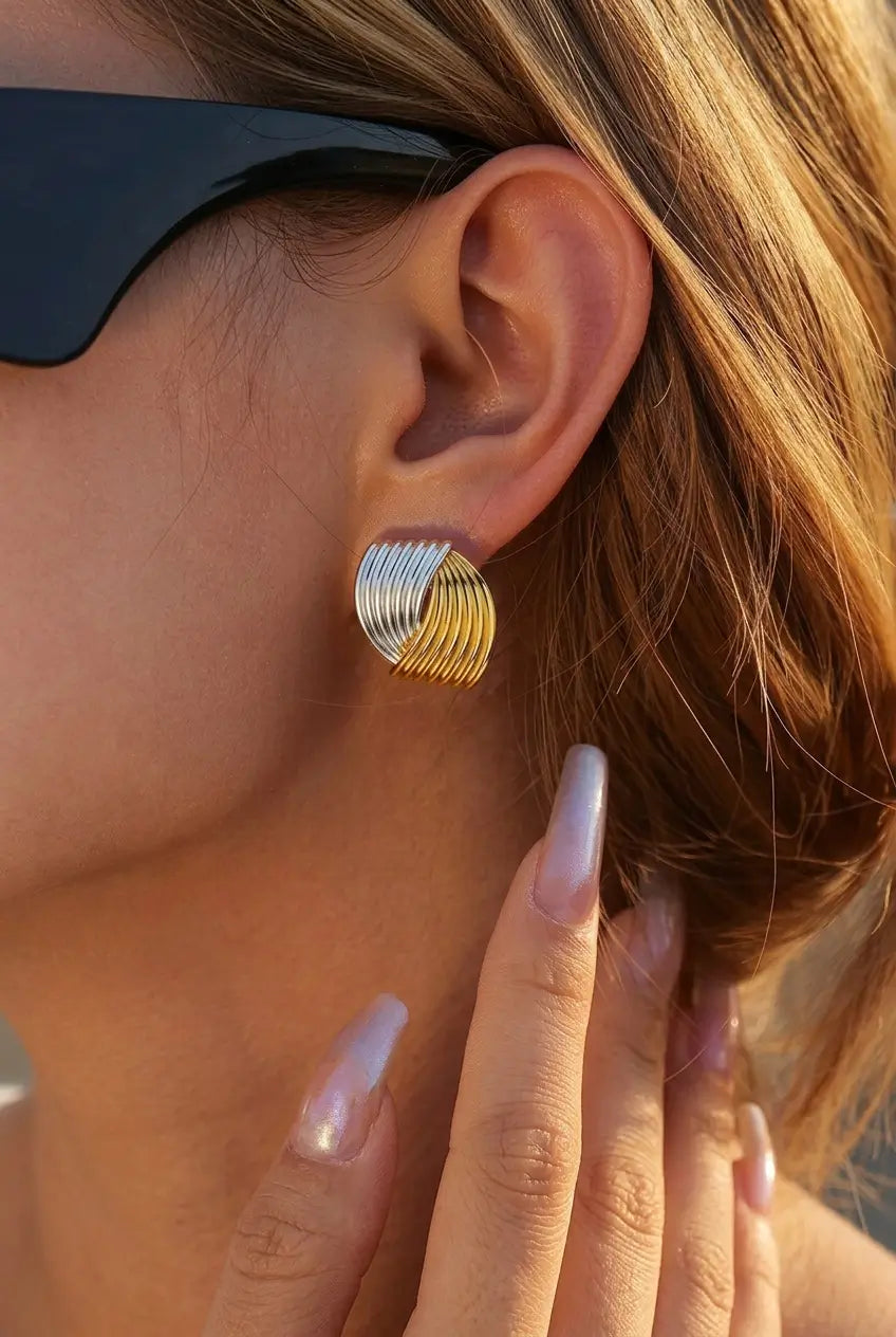Two-tone wire coil stud earrings worn on ear — YUBAMA waterproof gold silver stud earrings