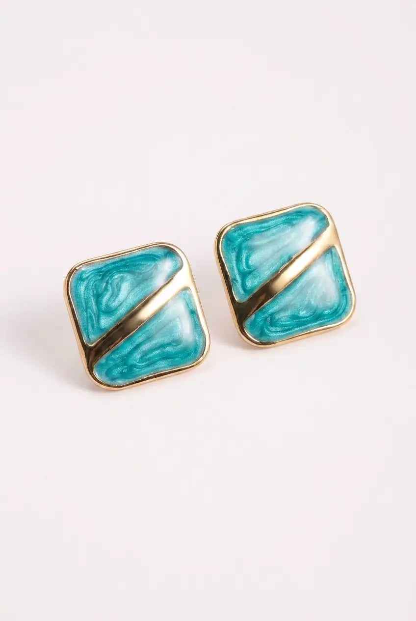 A pair of square stud earrings with a gold-tone metal border and a diagonal split design featuring turquoise blue and white marbled enamel.